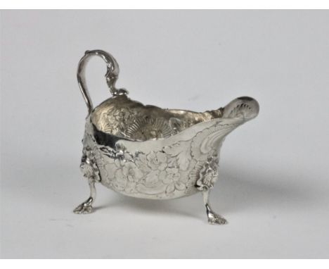 An 18th Century Irish silver Sauceboat, Dublin, with marks worn, decorated with floral repoussé design, and an acanthus leaf 