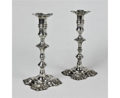 An attractive pair of 18th Century Irish cast silver Candlesticks, Dublin, the removable sconces decorated with shells and nu