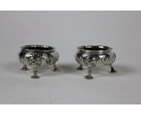 A pair of Irish Georgian silver circular Salts, with waved rims the bodies decorated with bands of flowers on three masked ca