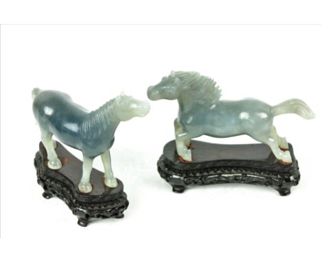 A cased pair of 20th Century Chinese Celadon jade carved Horses, on hardwood pierced bases, each approx. 11cms (4 1/2") high 