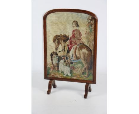 A Victorian walnut framed Firescreen, with central needlework tapestry, depicting a young lady on horseback, with dogs in a l