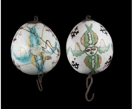 A GROUP OF TWO (2) KUTAHYA CERAMIC EGGS / HANGING ORNAMENTS  KUTAHYA, 18TH CENTURY  The first one is adorned in green, yellow