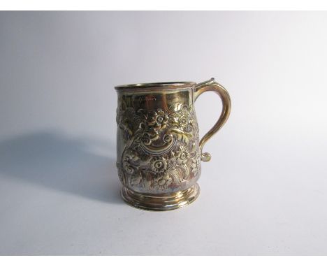 A Georgian silver embossed tankard with monogrammed cartouche, inscription to top rim, 1cm split to border of cartouche, 199c