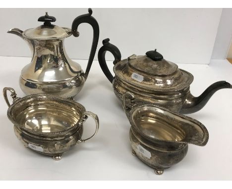 A George V silver four piece tea set comprising teapot, hot water jug, twin-handled sucrier and  milk jug of rectangular bell