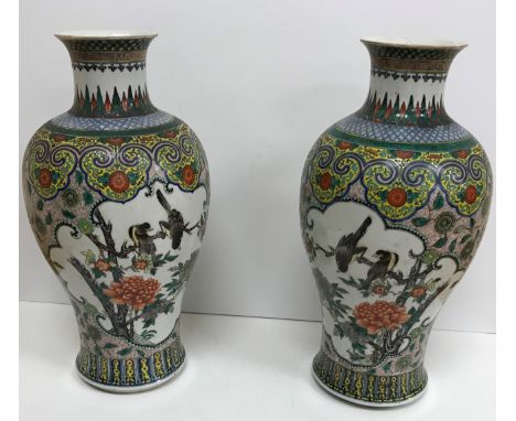 A pair of 19th Century Chinese polychrome decorated baluster shaped vases decorated with panels of peacock and birds amongst 