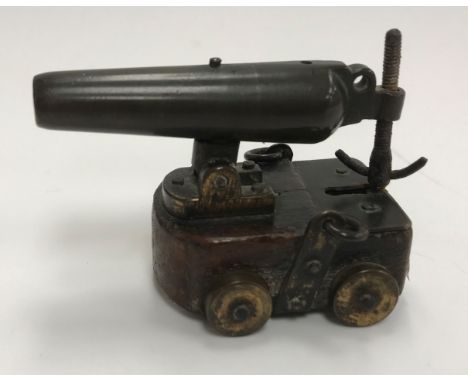 A 19th Century bronze miniature model of a Carronade canon, raised on a wooden base and mounted with adjustable moving handle