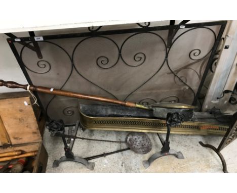 A wrought iron spark guard together with a pierced brass fender, brass warming pan, a pair of wrought iron fire dogs bearing 