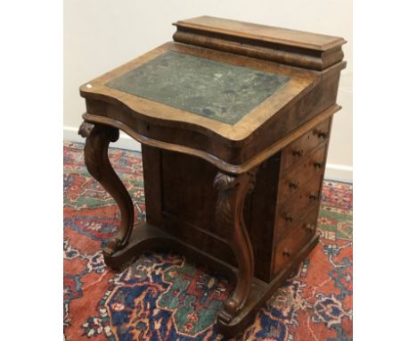 A Victorian burr walnut veneered Davenport desk, the stationery compartment top opening to reveal inkwell compartments and li
