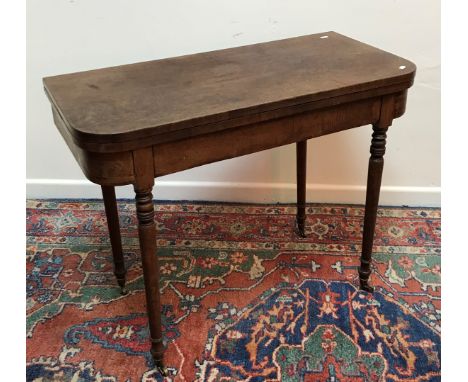 An early 19th Century mahogany foldover card table, the rounded rectangular top opening to reveal a baize lined interior over