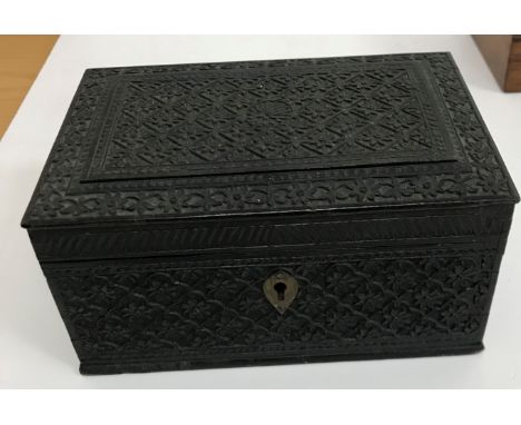 A circa 1900 carved ebony box of rectangular form with all over floral lozenge medallion decoration opening to reveal a cedar