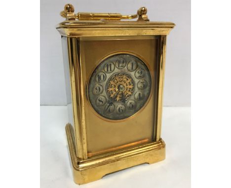 A circa 1900 French lacquer brass cased carriage clock, the silvered circular dial with Arabic numerals within medallions enc