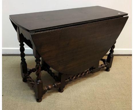 An oak oval gate leg drop leaf dining table on barley twist supports in the 17th Century style 121 cm x 153 cm x 76 cm high