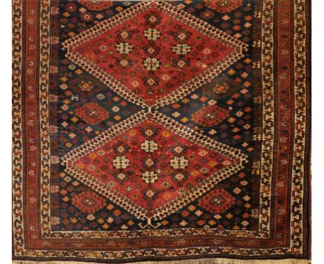 A TURKHAMAN TYPE PERSIAN CARPET, the dark blue ground with a madder central quadruple diamond pattern pole medallion, with ho