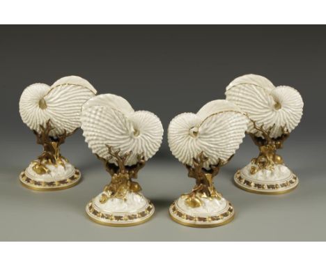 A SET OF FOUR ROYAL WORCESTER PORCELAIN VASES in the form of nautilus shells on naturalistic bases with applied shells, green