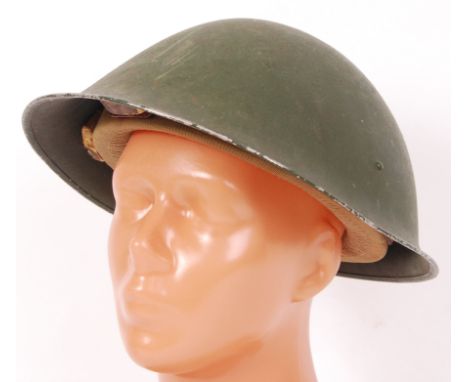 A post WWII Second World War uniform helmet. The inner liner marked CCL and dated 1959. Green, with peaked front.