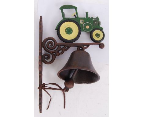 A vintage style 20th century cast iron bell with a green tractor mounted on top. Measures approximately 40cms tall. &nbsp;