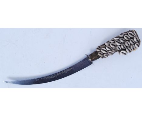 An early 20th century Indian ceremonial dagger. The handle decorated with shells, with a decorative curved blade. 38cm long. 