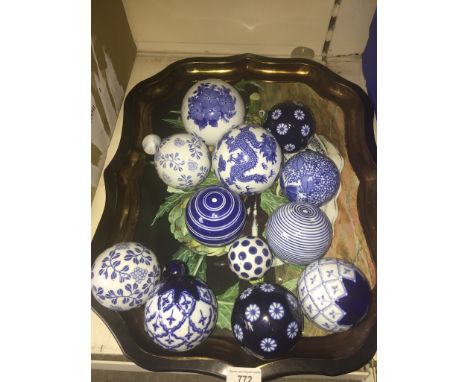 A metal tray containing 14 ceramic blue and white  balls 