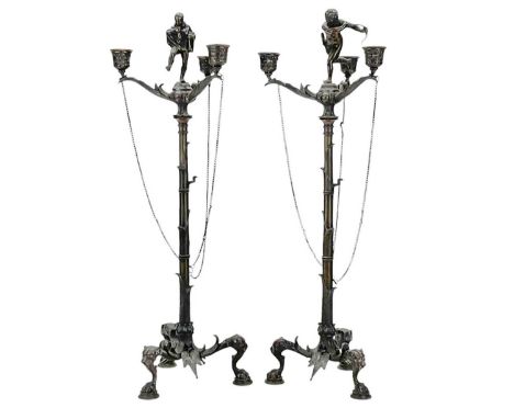A pair of ornate bronze three branch candelabra. 19th century, probably French, each with a figural mount, with simulated bam