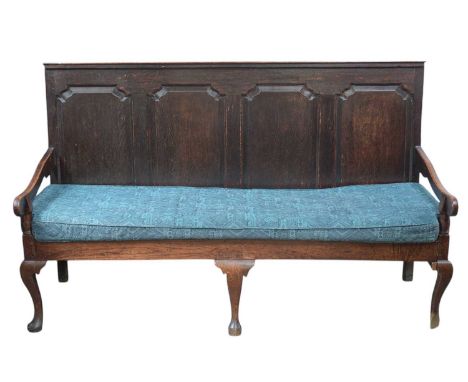 A George III oak settle with a quadruple fielded panel back.  On cabriole front legs, with a loose seat cushion upholstered i