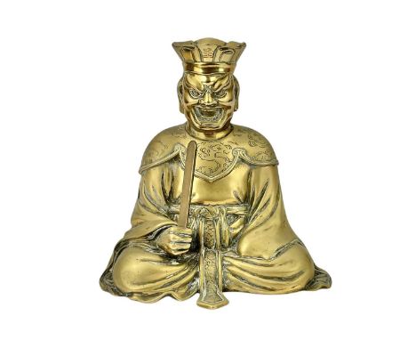 A Chinese polished brass figure of a god of wealth. Circa 1900, in a seated pose, with raised sword, character mark on the ba
