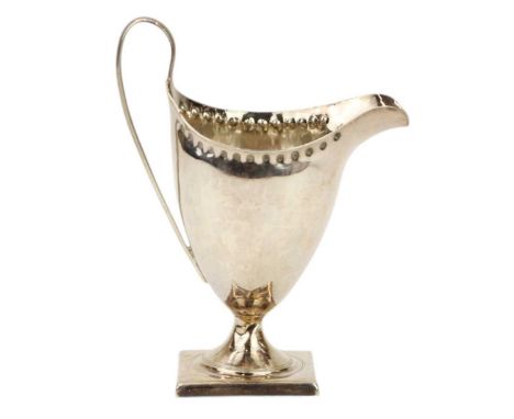 A Georgian helmet shaped cream jug. With punched border, and raised on square foot. Height 14cm. Maker's mark rubbed but prob