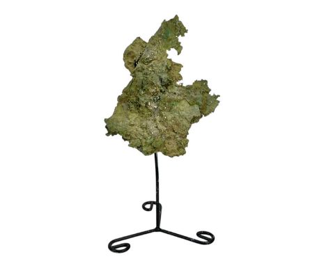 A Bronze Age freeform 'pancake' ingot. Height 24cm, on a stand, overall height 33.5cm.