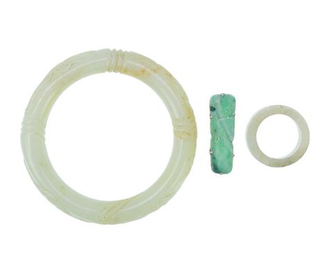 Jadeite bangle, ring and brooch. The bangle and brooch with carved decoration, internal bangle diameter 5.5cm and internal ri