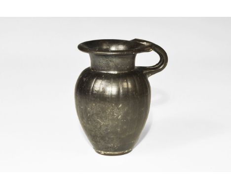 4th century BC. A ceramic blackware vessel with ovoid body, narrow neck, flared rim and loop handle.  155 grams, 11.5cm (4 1/