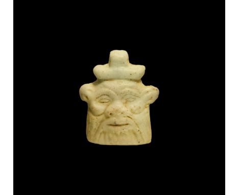 Third Intermediate Period, 1069-702 BC. A pale blue glazed composition planoconvex amuletic pendant of the mask of Bes, beard