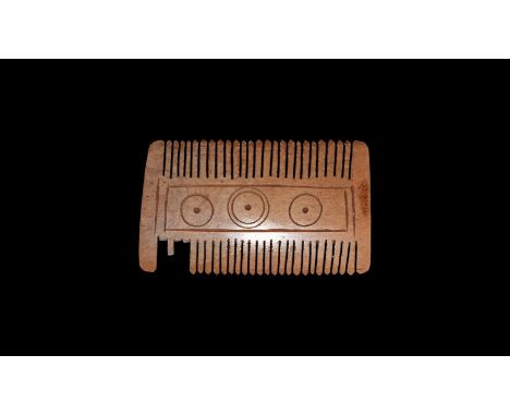 6th-9th century AD. A bone double-sided bone comb, elliptical in section, with fine-cut teeth and central band engraved with 