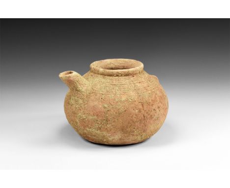 3rd-2nd millennium BC. A ceramic coarse grained red ware vessel with wide mouth and rolled rim; bulbous body with vertical li