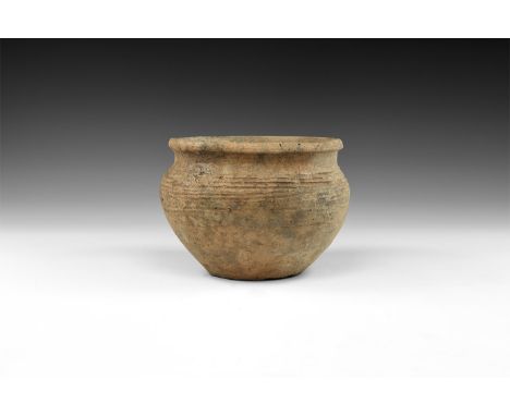 2nd millennium BC. A wheel-turned ceramic bowl with flat base, gussetted shoulder, everted rim, linear decoration.  602 grams