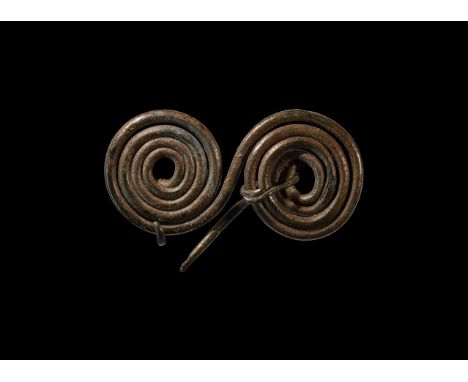 2nd millennium BC. A brooch formed as two conjoined bronze wire coils extending to a catch and pointed pin; two additional wi