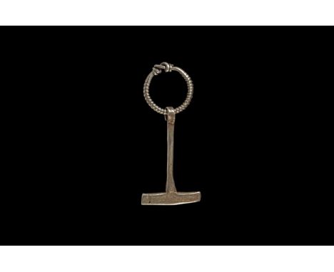 5th-6th century AD. A silver pendant formed as a stylised hammer with a long round-section tapering shaft and asymmetrical re