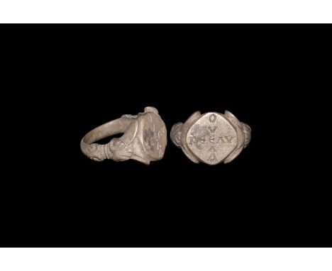 7th-9th century AD. A silver-gilt finger ring with D-section hoop, scrolled mouldings to the shoulders, flared leaves flaking