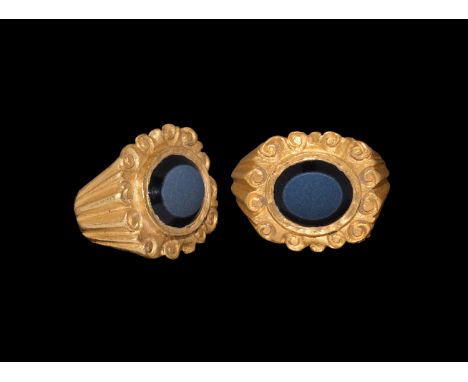 3rd century AD. A gold ring with D-section hoop and flat expanding fluted shoulders, scroll detailing to the plaque, central 