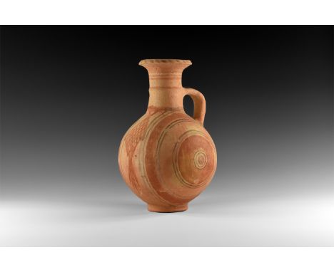 12th-10th century BC. A terracotta globular flask with trumpet-shaped neck with median carination, strap handle to the should