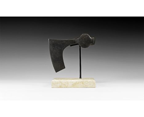 9th-11th century AD. An iron axehead, triangular in plan with long, slightly curved edge and square chin, round socket with l