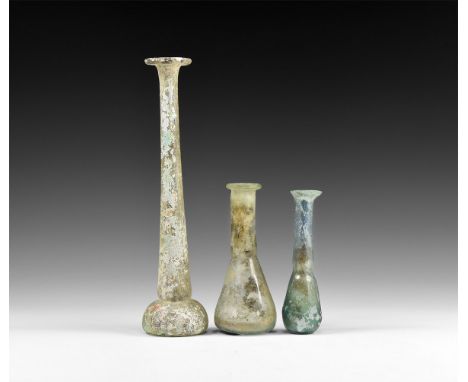 1st-4th century AD. A mixed group of glass vessels comprising: a very tall flask with bulbous body and dimple to the undersid