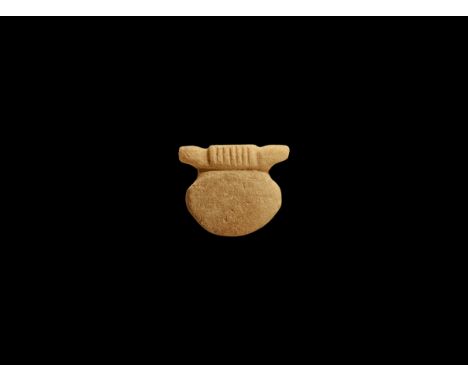Ptolemaic Period, 332-30 BC. A carved limestone amulet with domed disc attached to a transverse bar. Cf. Flinders Petrie, W.M