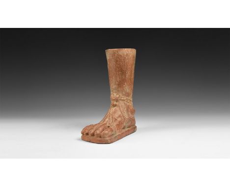 2nd-1st century BC. A carved stone foot and lower leg with detailed straps, hatched texture to the underside of the sole.  1.