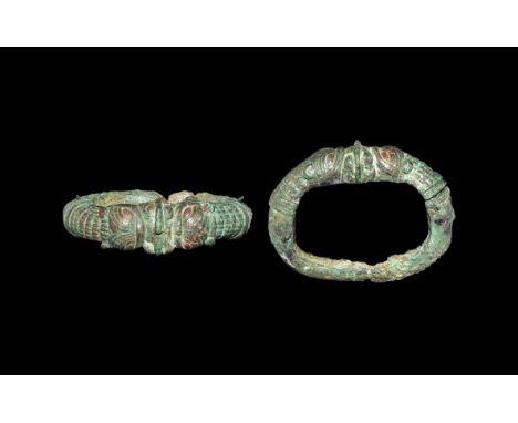 5th century BC. A substantial bronze bracelet with D-section penannular hoop, separately cast upper section with opposed beas