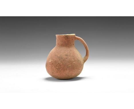 1st-3rd century AD. A small ceramic jug with bulbous body, everted rim and strap handle to the rear.  107 grams, 89mm (3 1/2"