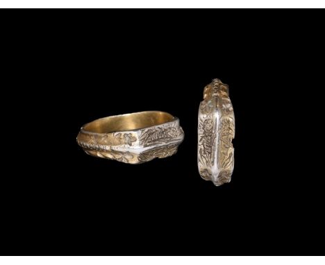 15th century AD. A silver-gilt finger ring comprising a hoop with median raised band and punch annulets, flared shoulders wit