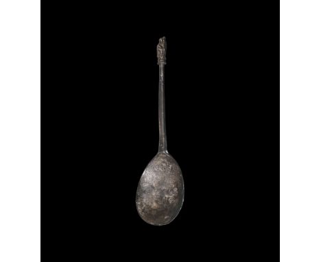 16th century AD. A pewter spoon with hexagonal-section shank, incised hatching to the upper shank, the finial a robed figure 