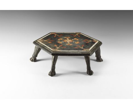 17th-18th century AD. A carved stone hexagonal table with six lion's claw legs, inlaid with mother of pearl and hard stone in