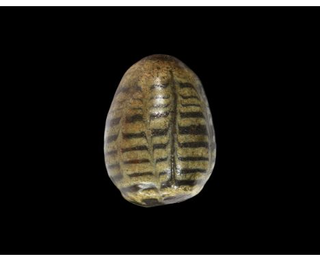 9th-11th century AD. A glazed hollow ceramic egg with a hole to the underside and smaller pellet inside; regular dragged yell