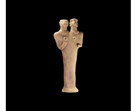 12th-7th century BC. A flat-backed ceramic figurine depicting a deity with two heads; the eyes and breasts formed with round 