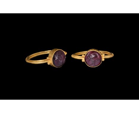 3rd-4th century AD. A garnet cabochon intaglio with stylised figure with three crescents, set into a later gold finger-ring c